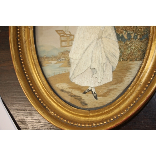 33 - A 19th century silk needlework oval panel depicting a young lady with white dress and bonnet holding... 