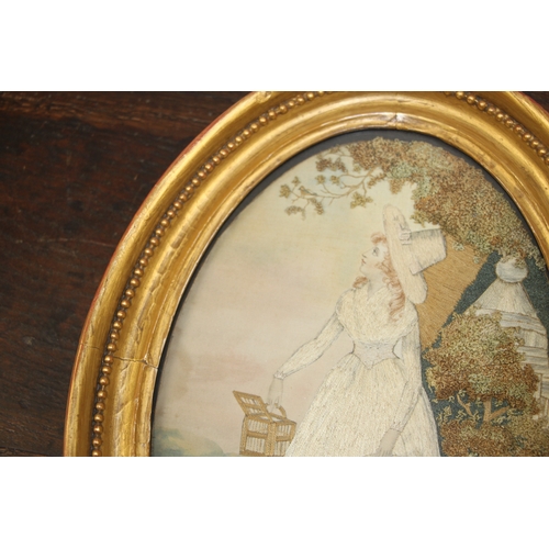 33 - A 19th century silk needlework oval panel depicting a young lady with white dress and bonnet holding... 