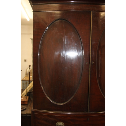 727 - A George III mahogany bowfront linen press with dentil cornice above a pair of panelled doors enclos... 