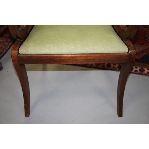 697 - A Regency mahogany desk chair with upholstered drop-in seat, on sabre front supports.