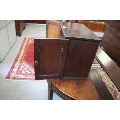 573 - A late 19th / early 20th century oak table top cupboard, the pair of doors enclosing pigeon holes, 4... 