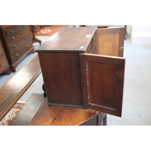 573 - A late 19th / early 20th century oak table top cupboard, the pair of doors enclosing pigeon holes, 4... 