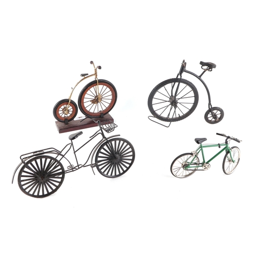 10 - A group of model bikes to include a Penny Farthing and butcher's bike, the largest 23cms high (4).