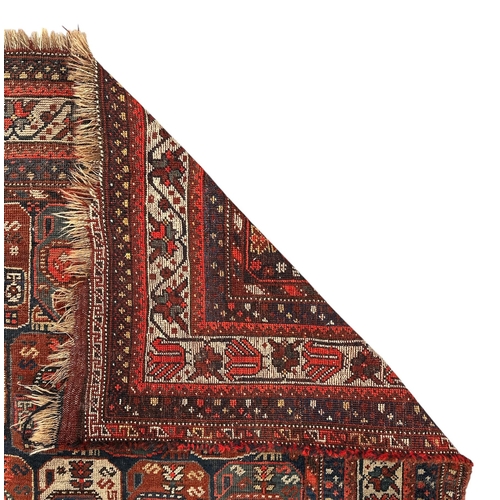 125 - A Persian Bakhtiar rug decorated with a multitude of medallions, on a red ground, 165 by 200cms.