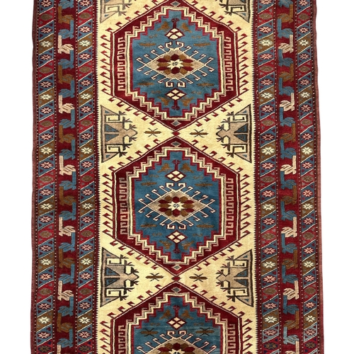 131 - A Caucasian Shirvan rug with three central medallions, on a red ground, 130 by 235cms.