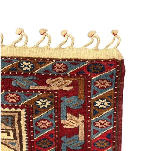 131 - A Caucasian Shirvan rug with three central medallions, on a red ground, 130 by 235cms.