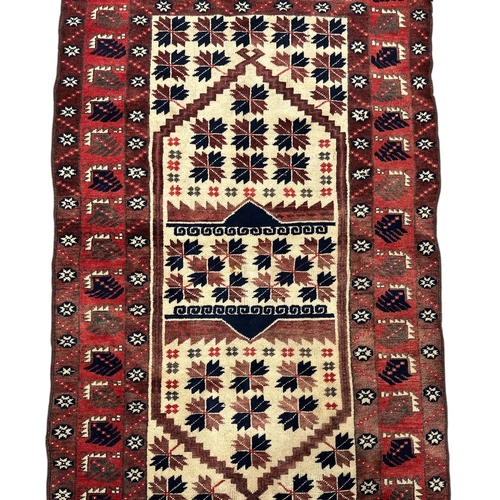 132 - A Persian Hamadan rug with stylised leaf decoration, on a red ground, 105 by 185cms.