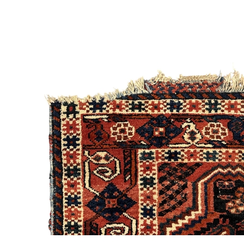 133 - A Persian Shiraz rug with two central medallions, on a pale red ground, 92 by 127cms.