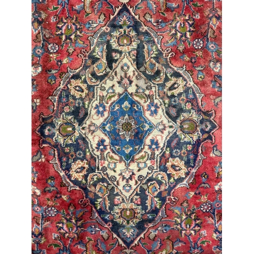 138 - A Persian Shiraz carpet, the central medallion within floral borders, 290 by 380cms.