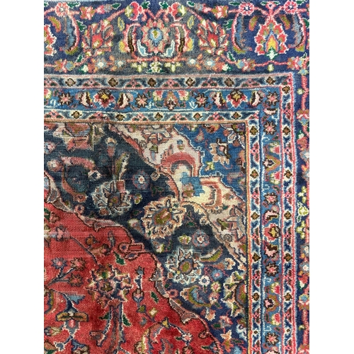 138 - A Persian Shiraz carpet, the central medallion within floral borders, 290 by 380cms.