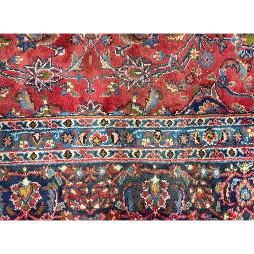 138 - A Persian Shiraz carpet, the central medallion within floral borders, 290 by 380cms.