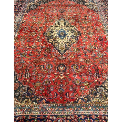 138 - A Persian Shiraz carpet, the central medallion within floral borders, 290 by 380cms.