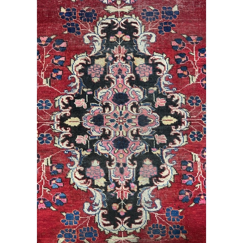 141 - A Persian Baluch runner with central floral medallion and blue spandrels, on a red ground, 95 by 220... 