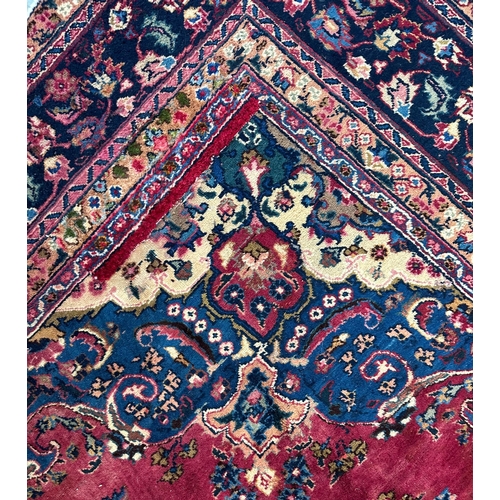 142 - A Persian hand knotted woollen rug with central gul within multi borders, 370 by 290cms.