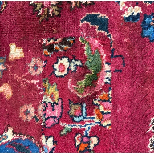 142 - A Persian hand knotted woollen rug with central gul within multi borders, 370 by 290cms.