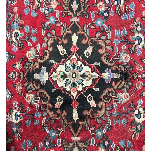 144 - A Persian Hamadan woollen hand knotted rug with central floral gul, on a beige ground, 155 by 225cms