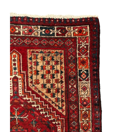 147 - A Persian hand knotted woollen Hamadan runner with three central geometric guls within geometric fie... 