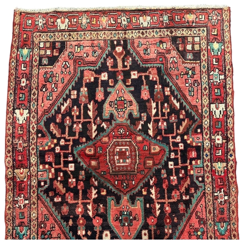 149 - A Persian Hamadan hand knotted rug, the central medallions within stylised borders, on a red ground,... 