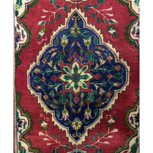 153 - A Persian Tabriz woollen rug, the central floral medallion within floral borders and floral corner b... 