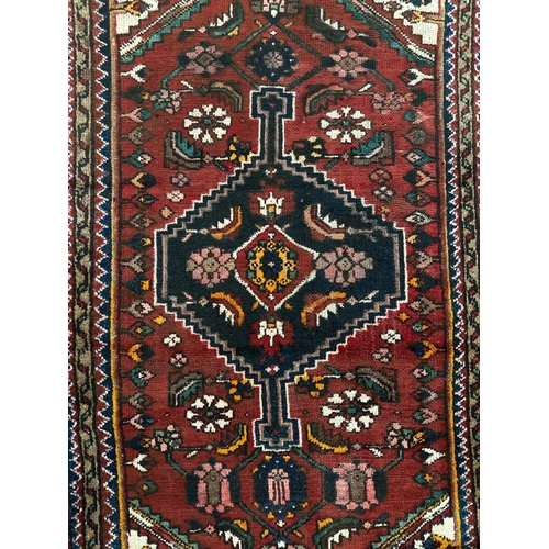 154 - A Persian Hamadan hand knotted woollen rug, the central stylised floral medallion within multi guard... 