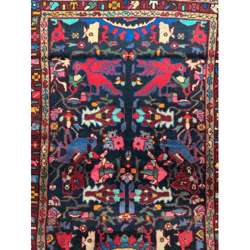 156 - A Persian hand knotted Hamadan woollen rug with stylised bird motifs within stylised guard borders, ... 