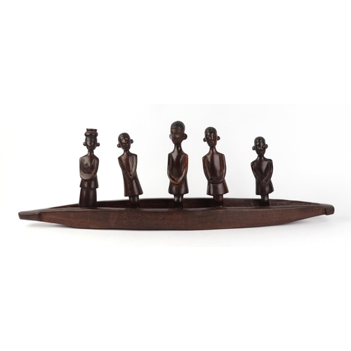 26 - An African hardwood carved figural group depicting a canoe and five figures, 70cms long.