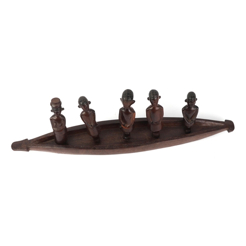 26 - An African hardwood carved figural group depicting a canoe and five figures, 70cms long.