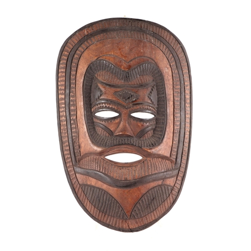 27 - An African tribal carved hardwood mask, 47cms high.