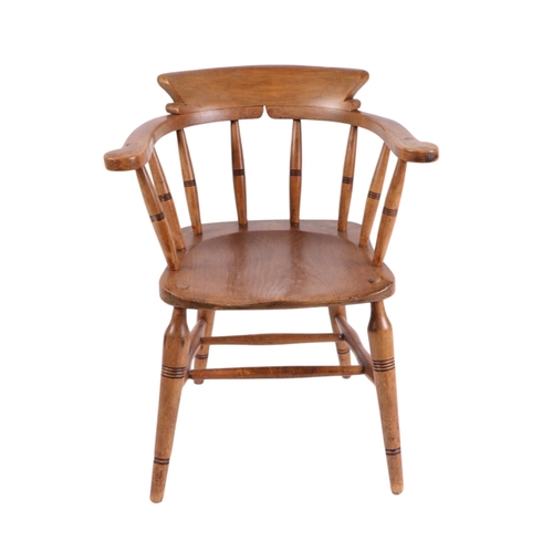 828 - A late Victorian oak smoker's bow armchair with spindle back, solid seat and turned front legs joine... 