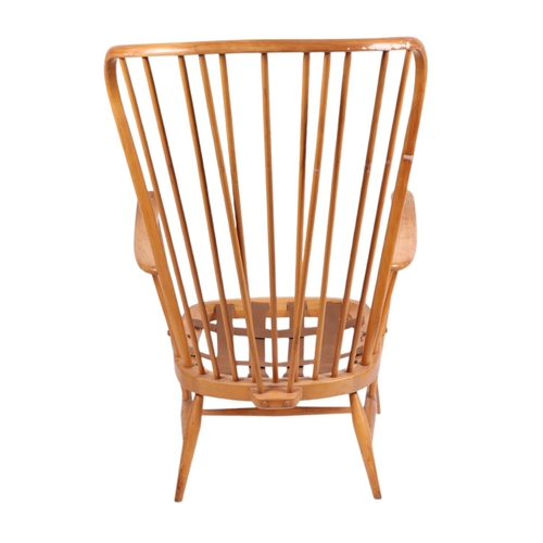 838 - A mid century blonde Ercol stick back armchair.