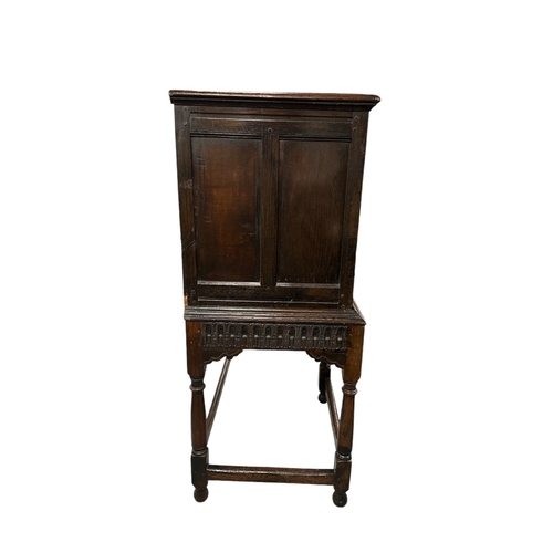 831 - A 17th century Jacobean oak food or dole cupboard on stand, the cabinet with a pair of panelled door... 