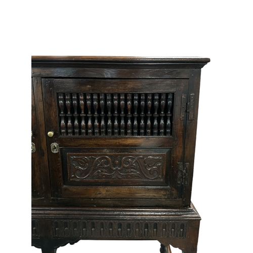 831 - A 17th century Jacobean oak food or dole cupboard on stand, the cabinet with a pair of panelled door... 