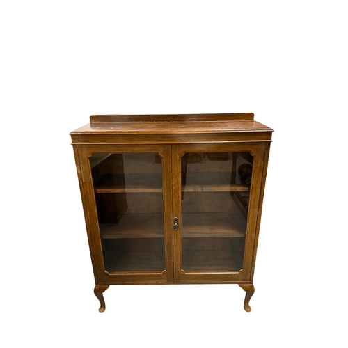 817 - An Edwardian walnut glazed bookcase, the pair of glazed panelled doors enclosing a shelved interior,... 