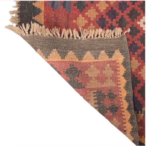 130 - A Kilim rug with geometric design, on a red ground, 95 by 178cms.