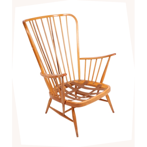 838 - A mid century blonde Ercol stick back armchair.