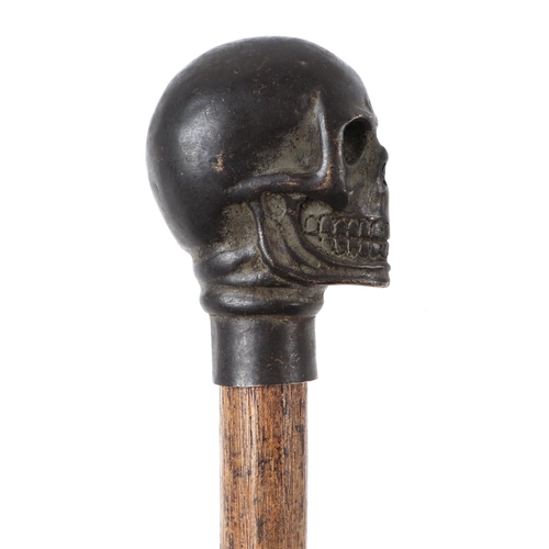 1653 - A vintage walking stick with bronze skull handle, 100cms long.