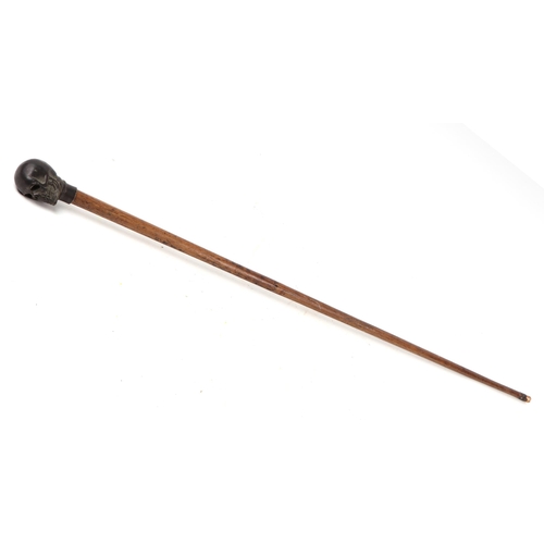 1653 - A vintage walking stick with bronze skull handle, 100cms long.