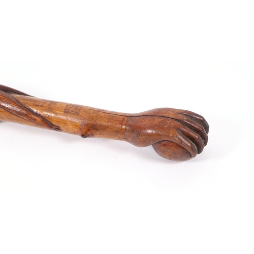 1655 - A folk art walking stick, the shaft carved with entwined snakes, the terminal in the form of a hand ... 