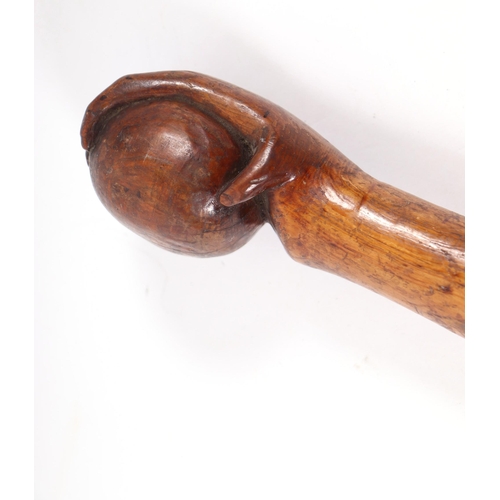 1655 - A folk art walking stick, the shaft carved with entwined snakes, the terminal in the form of a hand ... 