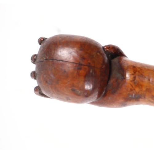 1655 - A folk art walking stick, the shaft carved with entwined snakes, the terminal in the form of a hand ... 