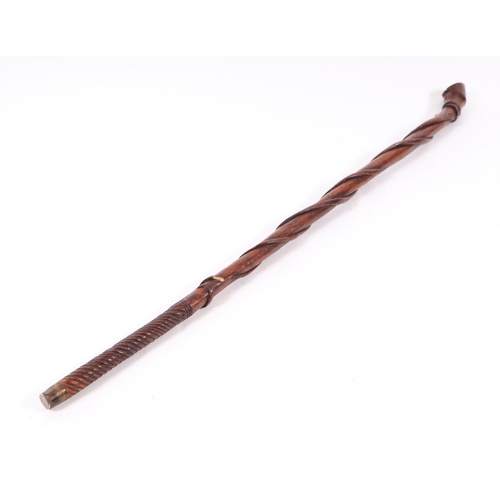 1656 - A folk art walking stick, the shaft carved with entwined snakes, the terminal in the form of a clove... 