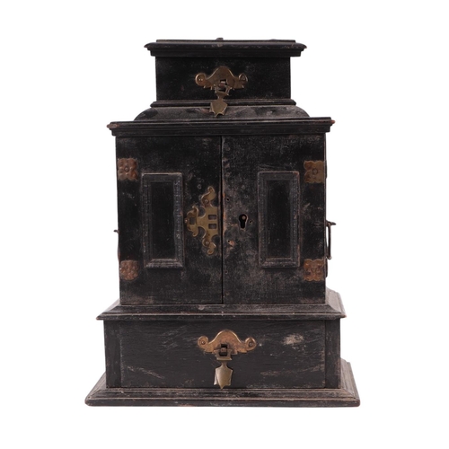 1697 - An 18th century continental ebonised table cabinet, the lift-up top above a pair of doors with a dra... 