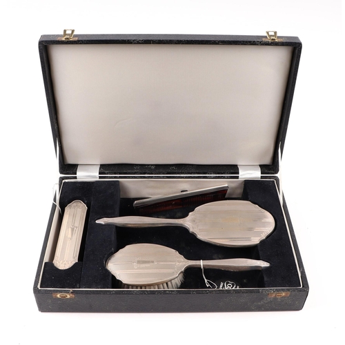 1817 - A boxed four-piece silver backed dressing table set.