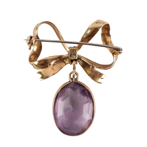 1936 - An 18ct gold and blue enamel bow brooch with amethyst pendant drop, 3.5cms wide, 6.4g.