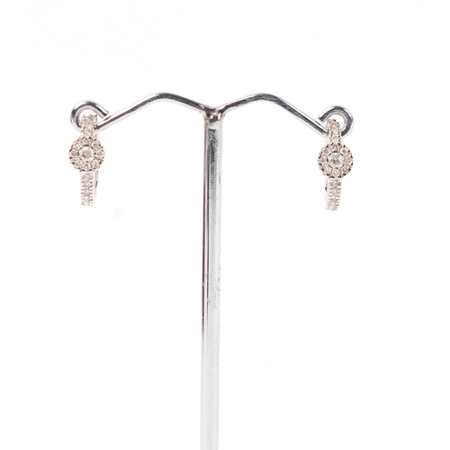 1943 - A pair of 18ct white gold diamond set hoop earrings, 2.3g.