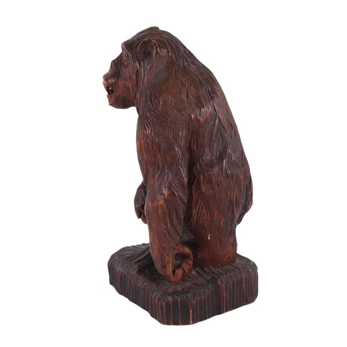 242 - A Black Forest style carving of a gorilla standing on a rocky plinth, signed 'F Wolf to rear, remnan... 