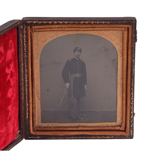 250 - A 19th century American Tintype of a soldier in uniform holding a sword, in original leather case, o... 