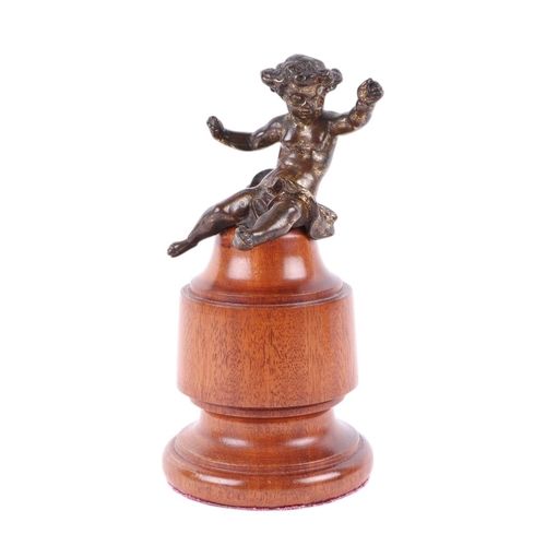 274 - After the antique:  A bronze figure of a cherub, mounted on a turned wooden socle, 21cms high; toget... 