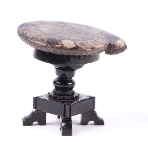 289 - A Whitby jet model of an occasional table with polished ammonite top on a quatrefoil base, 4.5cms hi... 