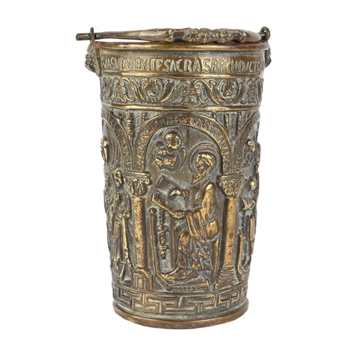 298 - An ornate repoussé brass holy water bucket / pail situla depicting saints, 19cms high.